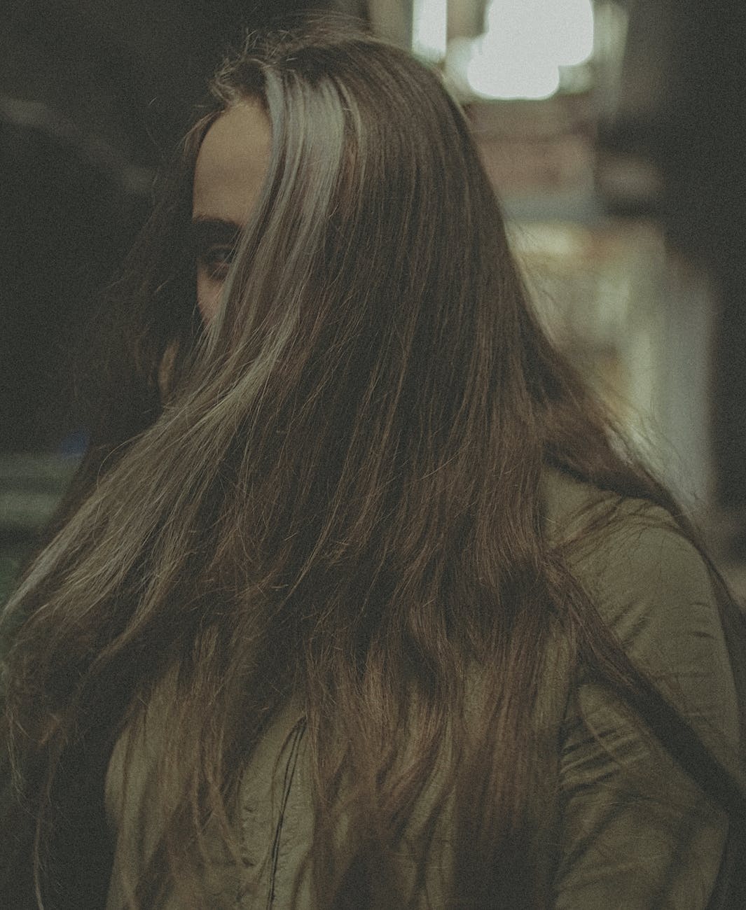 A person whose long hair is hiding their face almost completely